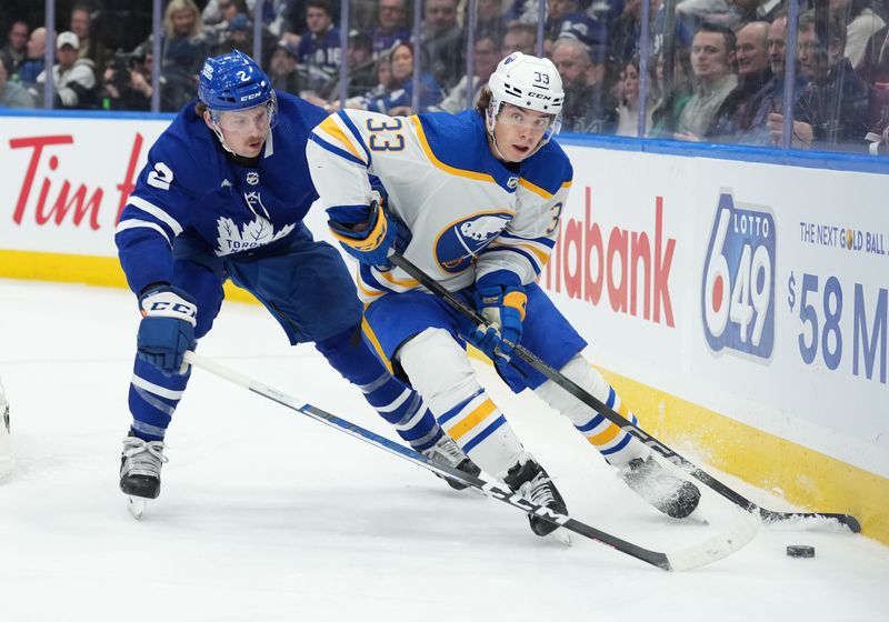 Mar 6, 2024; Toronto, Ontario, CAN; Buffalo Sabres defenseman Ryan Johnson (33) battles for the puck withToronto Maple Leafs defenseman Simon Benoit (2) during the third period at Scotiabank Arena. Mandatory Credit: Nick Turchiaro-USA TODAY Sports