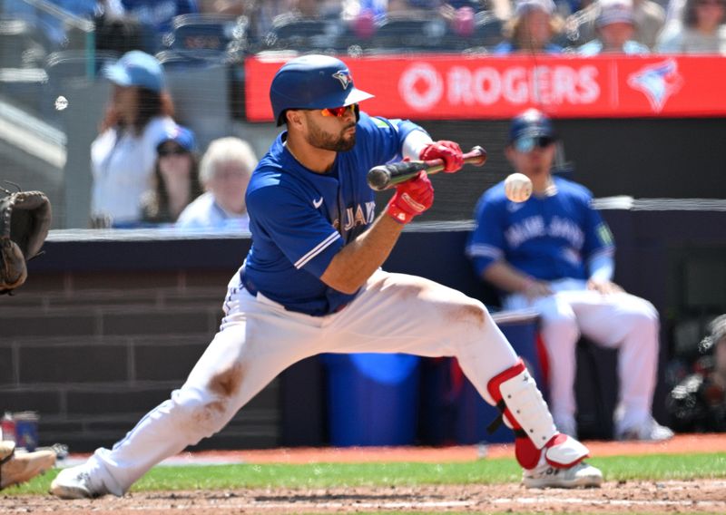 May 19, 2024; Toronto, Ontario, CAN;  Toronto Blue Jays third baseman Isiah Kiner-Falefa (7) hits a sacrifice bunt against the Tampa Bay Rays in the sixth inning at Rogers Centre. Mandatory Credit: Dan Hamilton-USA TODAY Sports