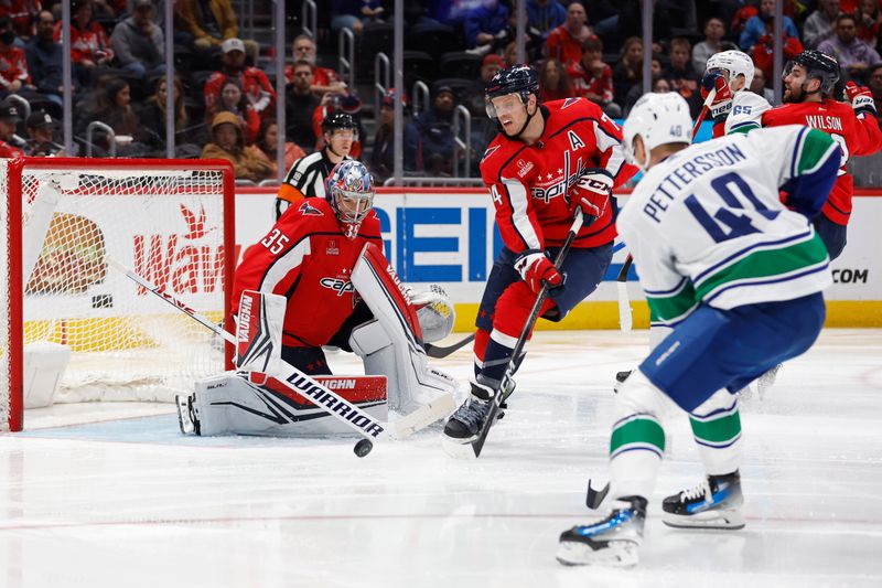 Feb 11, 2024; Washington, District of Columbia, USA; Washington Capitals goaltender Darcy Kuemper (35) makes a save on Vancouver Canucks center Elias Pettersson (40) in the second period at Capital One Arena. Mandatory Credit: Geoff Burke-USA TODAY Sports