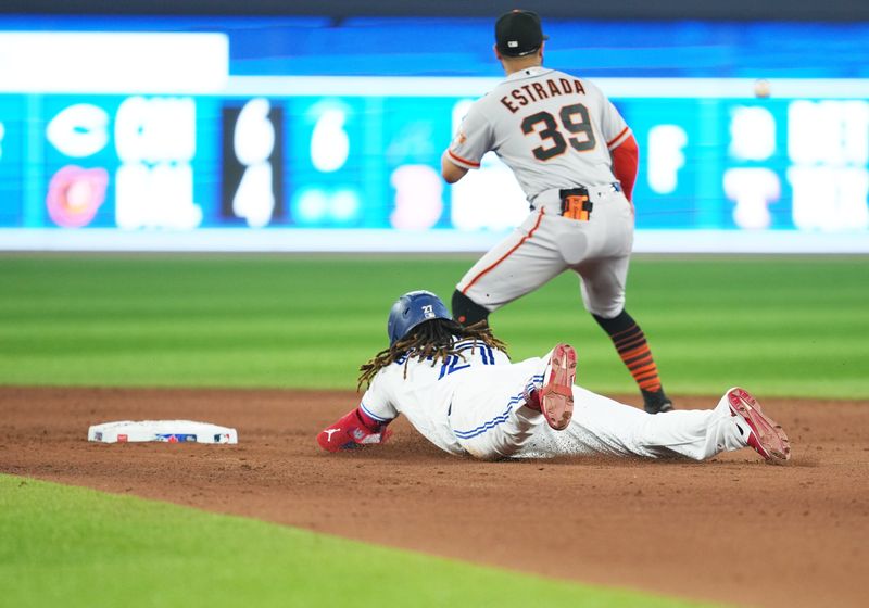 Jun 28, 2023; Toronto, Ontario, CAN; Toronto Blue Jays first baseman Vladimir Guerrero Jr. (27) slides into second base ahead of the tag from San Francisco Giants second baseman Thairo Estrada (39) during the eighth inning at Rogers Centre. Mandatory Credit: Nick Turchiaro-USA TODAY Sports