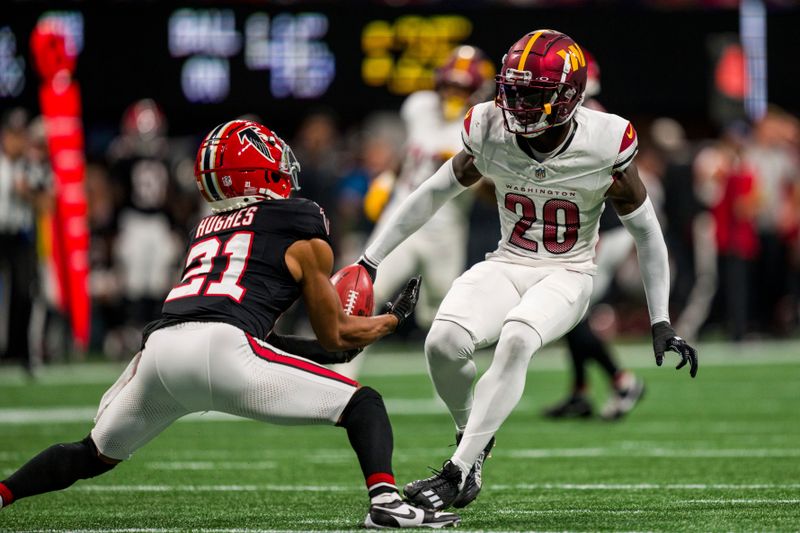 Atlanta Falcons cornerback Mike Hughes (21) catches a punt as Washington Commanders safety Jartavius Martin (20) approaches during the second half of an NFL football game, Sunday, Oct. 15, 2023, in Atlanta. The Washington Commanders won 24-16. (AP Photo/Danny Karnik)