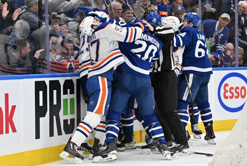 Mar 23, 2024; Toronto, Ontario, CAN; Edmonton Oilers forward Connor McDavid (97) and Toronto Maple Leafs defenseman Joel Edmundson (20) participate in a scuffle during the second period at Scotiabank Arena. Mandatory Credit: Dan Hamilton-USA TODAY Sports