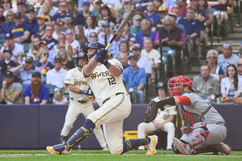 Sep 2, 2024; Milwaukee, Wisconsin, USA; Milwaukee Brewers first baseman Rhys Hoskins (12) hits a 2-run home run in the fourth inning as St. Louis Cardinals catcher Pedro Pages (43) looks on at American Family Field. Mandatory Credit: Benny Sieu-USA TODAY Sports