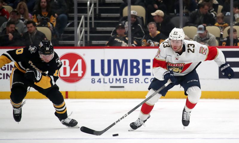 Dec 3, 2024; Pittsburgh, Pennsylvania, USA;  Florida Panthers center Carter Verhaeghe (23) moves the puck up ice as Pittsburgh Penguins left wing Drew O'Connor (10) chases during the second period at PPG Paints Arena. Mandatory Credit: Charles LeClaire-Imagn Images