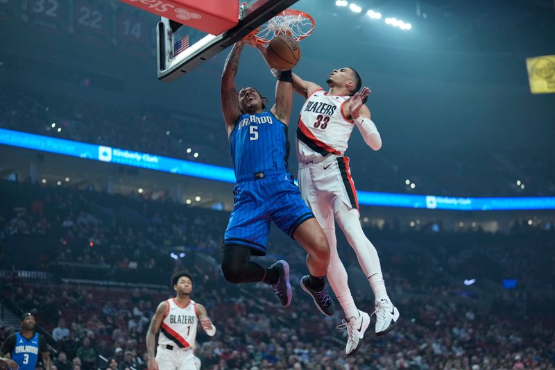 PORTLAND, OREGON - JANUARY 30: Paolo Banchero #5 of the Orlando Magic dunks the ball past Toumani Camara #33 of the Portland Trail Blazers during the first half at Moda Center on January 30, 2025 in Portland, Oregon. NOTE TO USER: User expressly acknowledges and agrees that, by downloading and or using this photograph, User is consenting to the terms and conditions of the Getty Images License Agreement. (Photo by Soobum Im/Getty Images)