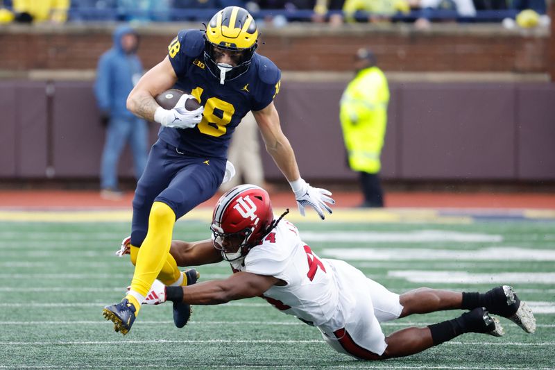 Oct 14, 2023; Ann Arbor, Michigan, USA; Michigan Wolverines tight end Colston Loveland (18) avoids a tackle by Indiana Hoosiers linebacker Aaron Casey (44) in the first half at Michigan Stadium. Mandatory Credit: Rick Osentoski-USA TODAY Sports