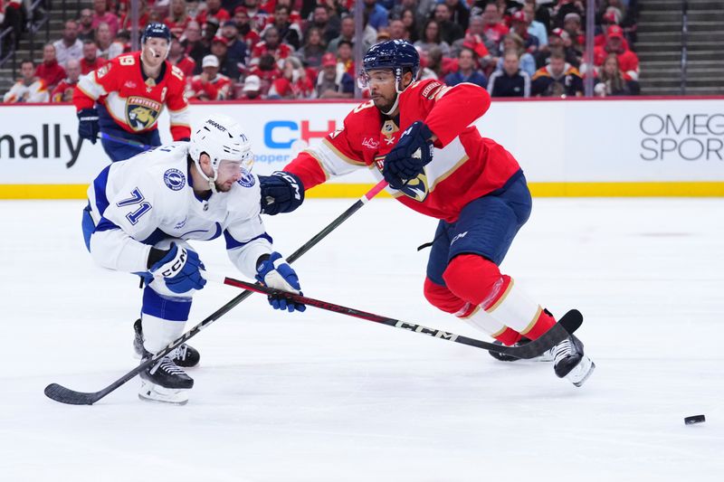 Apr 28, 2025; Sunrise, Florida, USA;Tampa Bay Lightning center Anthony Cirelli (71) controls the puck against Florida Panthers defenseman Seth Jones (3) during the second period in game four of the first round of the 2025 Stanley Cup Playoffs at Amerant Bank Arena. Mandatory Credit: Rich Storry-Imagn Images