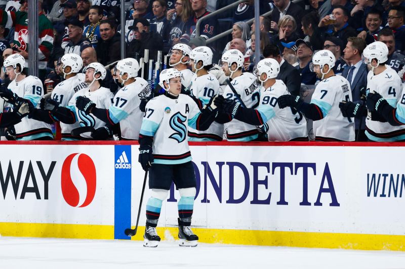 Apr 16, 2024; Winnipeg, Manitoba, CAN;  Seattle Kraken forward Yanni Gourde (37) is congratulated by teammates after a goal against the Winnipeg Jets during the second period at Canada Life Centre. Mandatory Credit: Terrence Lee-USA TODAY Sports