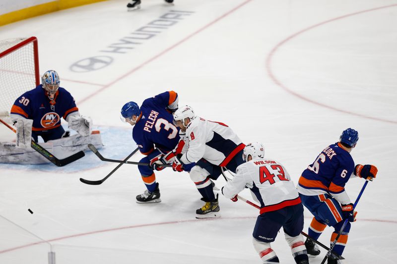 Apr 6, 2025; Elmont, New York, USA;  -Washington Capitals forward Alex Ovechkin (8) reaches for the puck against New York Islanders defenseman Adam Pelech (3) and goaltender Ilya Sorokin (30) during the first period at UBS Arena. Mandatory Credit: Geoff Burke-Imagn Images