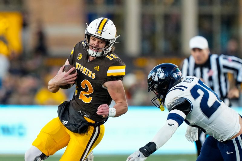 Oct 26, 2024; Laramie, Wyoming, USA; Wyoming Cowboys quarterback Kaden Anderson (12) runs against the Utah State Aggies during the first quarter at Jonah Field at War Memorial Stadium. Mandatory Credit: Troy Babbitt-Imagn Images