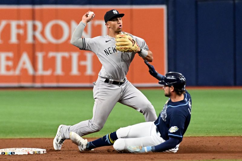 Aug 26, 2023; St. Petersburg, Florida, USA; New York Yankees shortstop Oswaldo Peraza (91) attempts to turn a double play as Tampa Bay Rays right fielder Josh Lowe (15) slides in the eighth inning at Tropicana Field. Mandatory Credit: Jonathan Dyer-USA TODAY Sports