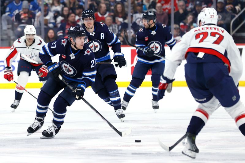 Mar 11, 2024; Winnipeg, Manitoba, CAN; Winnipeg Jets left wing Nikolaj Ehlers (27) skates through the neutral zone past Washington Capitals defenseman Alexander Alexeyev (27) in the second period at Canada Life Centre. Mandatory Credit: James Carey Lauder-USA TODAY Sports