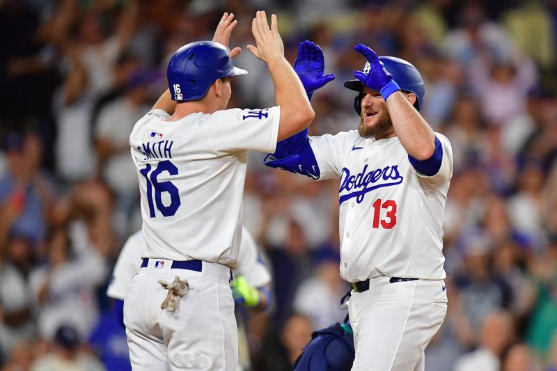 Aug 19, 2024; Los Angeles, California, USA; Los Angeles Dodgers third baseman Max Muncy (13) is greeted by catcher Will Smith (16) after hitting a two run home run against the Seattle Mariners during the seventh inning at Dodger Stadium. Mandatory Credit: Gary A. Vasquez-USA TODAY Sports