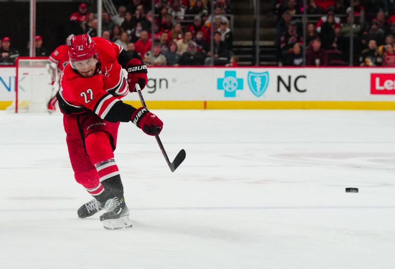 Jan 13, 2024; Raleigh, North Carolina, USA;  Carolina Hurricanes defenseman Brett Pesce (22) takes a shot against the Pittsburgh Penguins during the third period at PNC Arena. Mandatory Credit: James Guillory-USA TODAY Sports