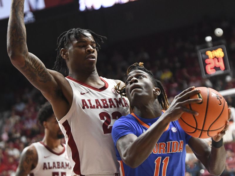 Feb 21, 2024; Tuscaloosa, Alabama, USA;  Alabama Crimson Tide forward Nick Pringle (23) stops a drive by Florida Gators guard Denzel Aberdeen (11) at Coleman Coliseum. Mandatory Credit: Gary Cosby Jr.-USA TODAY Sports