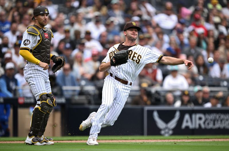 May 17, 2023; San Diego, California, USA; San Diego Padres relief pitcher Tom Cosgrove (right) throws to first base late as catcher Brett Sullivan (left) looks on during the eighth inning against the Kansas City Royals at Petco Park. Mandatory Credit: Orlando Ramirez-USA TODAY Sports