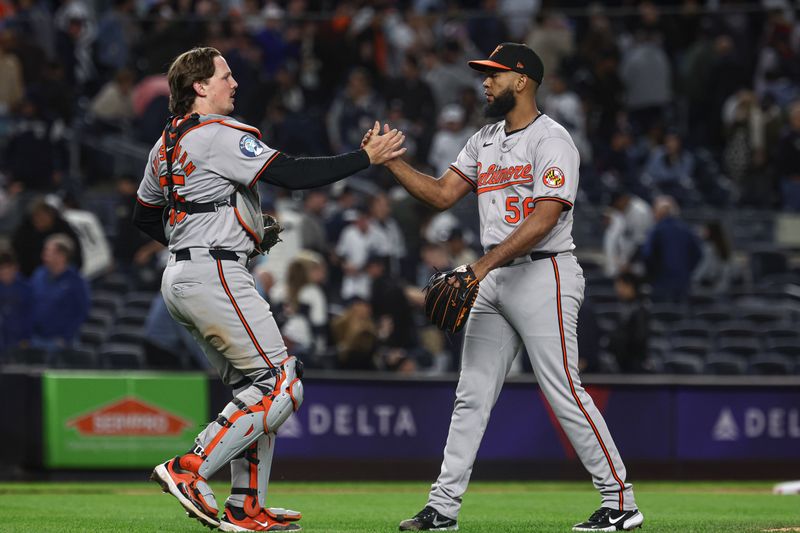 Sep 24, 2024; Bronx, New York, USA; Baltimore Orioles relief pitcher Seranthony Dominguez (56) and catcher Adley Rutschman (35) celebrates after deating the New York Yankees at Yankee Stadium. Mandatory Credit: Vincent Carchietta-Imagn Images