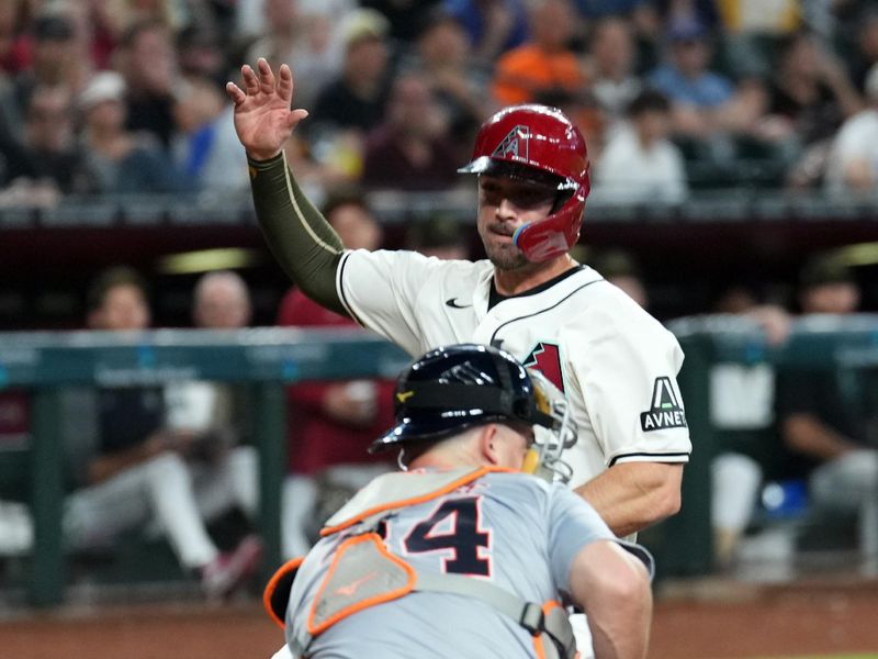 May 19, 2024; Phoenix, Arizona, USA; Arizona Diamondbacks catcher Tucker Barnhart (16) beats a throw to Detroit Tigers catcher Jake Rogers (34) to score a run during the seventh inning at Chase Field. Mandatory Credit: Joe Camporeale-USA TODAY Sports