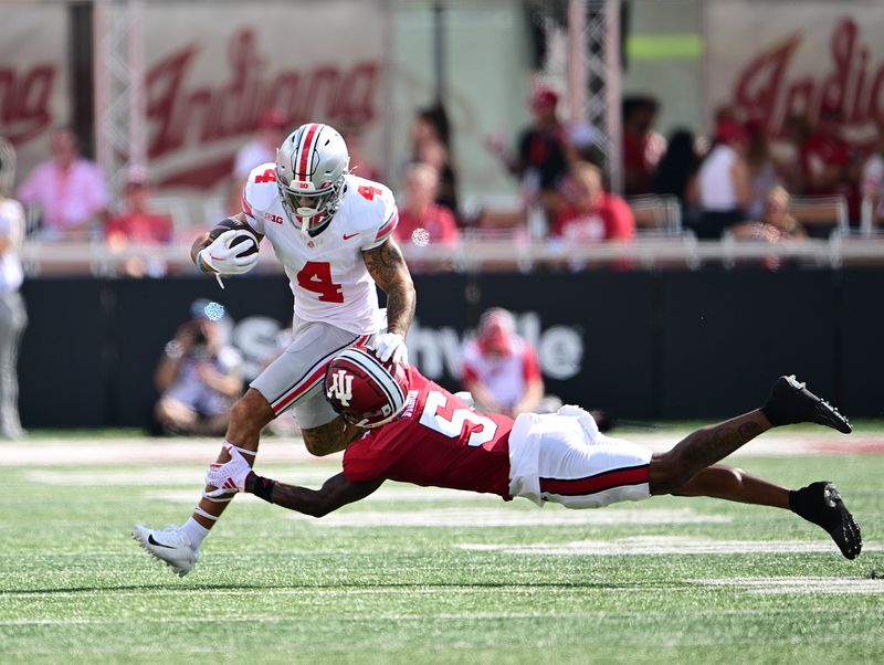 Sep 2, 2023; Bloomington, Indiana, USA; Ohio State Buckeyes wide receiver Julian Fleming (4) is tackled by Indiana Hoosiers defensive back Kobee Minor (5) during the second quarter at Memorial Stadium. Mandatory Credit: Marc Lebryk-USA TODAY Sports