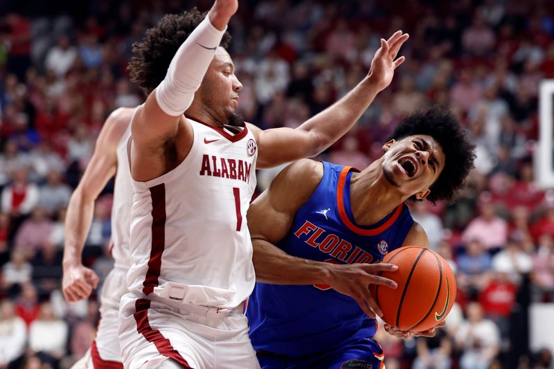 Feb 21, 2024; Tuscaloosa, Alabama, USA; Florida Gators guard Zyon Pullin (0) is fouled by Alabama Crimson Tide guard Mark Sears (1) as he drives to the basket during the second half at Coleman Coliseum. Mandatory Credit: Butch Dill-USA TODAY Sports