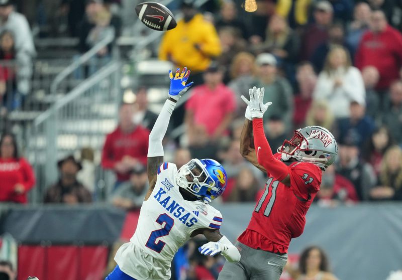 Dec 26, 2023; Phoenix, AZ, USA; UNLV Rebels wide receiver Ricky White (11) catches a touchdown pass against Kansas Jayhawks cornerback Cobee Bryant (2) during the second half at Chase Field. Mandatory Credit: Joe Camporeale-USA TODAY Sports