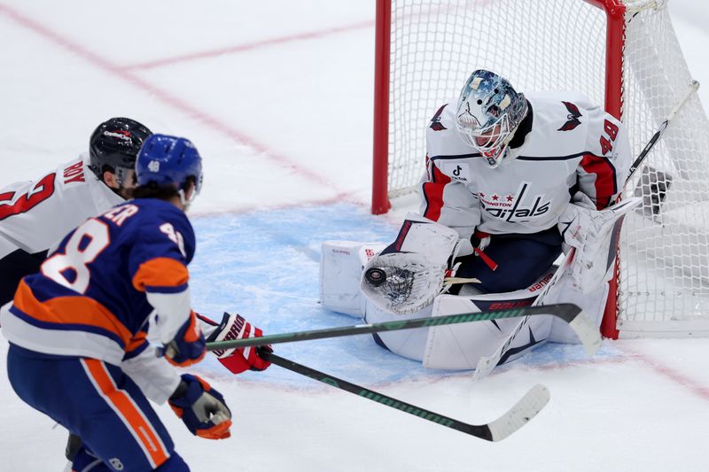 Oct 11, 2025; Elmont, New York, USA; Washington Capitals goaltender Logan Thompson (48) makes a save against New York Islanders defenseman Matthew Schaefer (48) during the third period at UBS Arena. Mandatory Credit: Brad Penner-Imagn Images