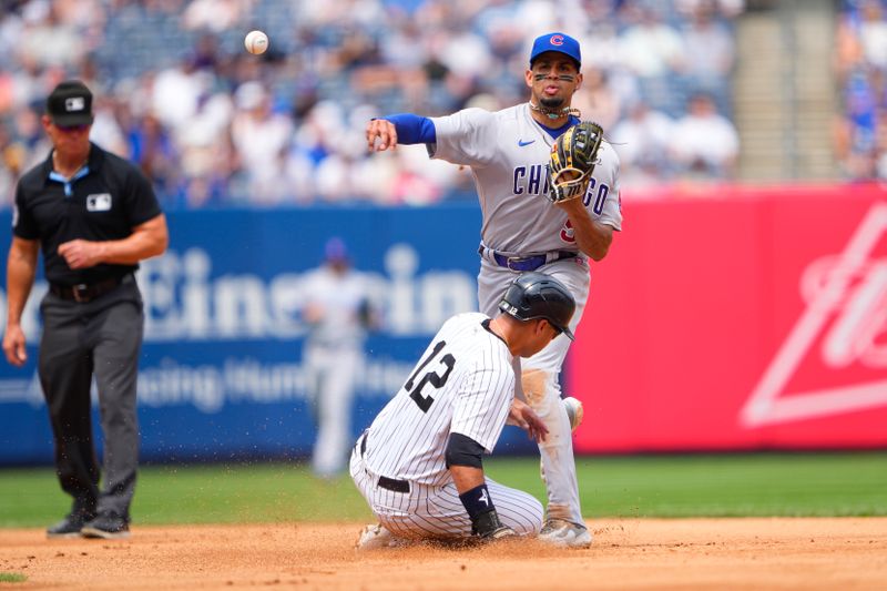 Jul 8, 2023; Bronx, New York, USA; Chicago Cubs second baseman Christopher Morel (5) turns a double play with New York Yankees left fielder Isiah Kiner-Falefa (12) sliding into second base during the fourth inning at Yankee Stadium. Mandatory Credit: Gregory Fisher-USA TODAY Sports