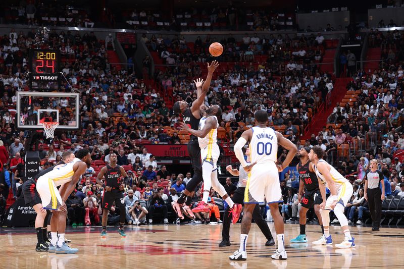 MIAMI, FL - MARCH 26: Bam Adebayo #13 of the Miami Heat and Draymond Green #23 of the Golden State Warriors go for the opening tip off during the game on March 26, 2024 at Kaseya Center in Miami, Florida. NOTE TO USER: User expressly acknowledges and agrees that, by downloading and or using this Photograph, user is consenting to the terms and conditions of the Getty Images License Agreement. Mandatory Copyright Notice: Copyright 2024 NBAE (Photo by Jeff Haynes/NBAE via Getty Images)