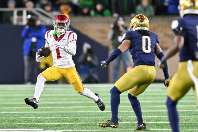 Oct 14, 2023; South Bend, Indiana, USA; USC Trojans wide receiver Zachariah Branch (1) runs the ball as Notre Dame Fighting Irish safety Xavier Watts (0) defends in the third quarter at Notre Dame Stadium. Mandatory Credit: Matt Cashore-USA TODAY Sports