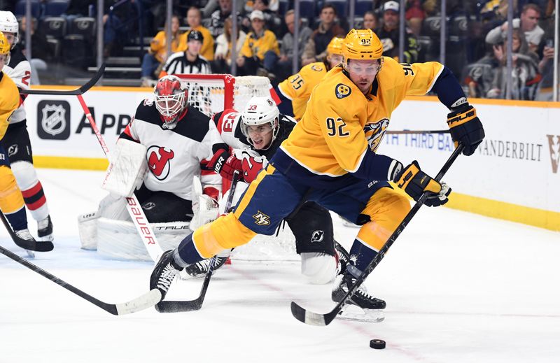 Jan 26, 2023; Nashville, Tennessee, USA; Nashville Predators center Ryan Johansen (92) handles the puck as he is pressured by New Jersey Devils defenseman Ryan Graves (33) during the first period at Bridgestone Arena. Mandatory Credit: Christopher Hanewinckel-USA TODAY Sports