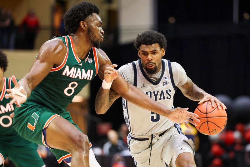 Nov 28, 2025; Kissimmee, FL, USA; Georgetown Hoyas guard Kj Lewis (5) is guarded by Miami (FL) Hurricanes center Ernest Udeh Jr. (8) in the first half during the ESPN Events Invitational at State Farm Field House. Mandatory Credit: Nathan Ray Seebeck-Imagn Images