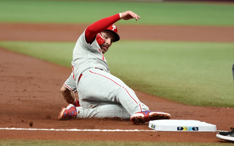 Jul 5, 2023; St. Petersburg, Florida, USA; Philadelphia Phillies second baseman Bryson Stott (5) slides into third base against the Tampa Bay Rays during the second inning  at Tropicana Field. Mandatory Credit: Kim Klement-USA TODAY Sports