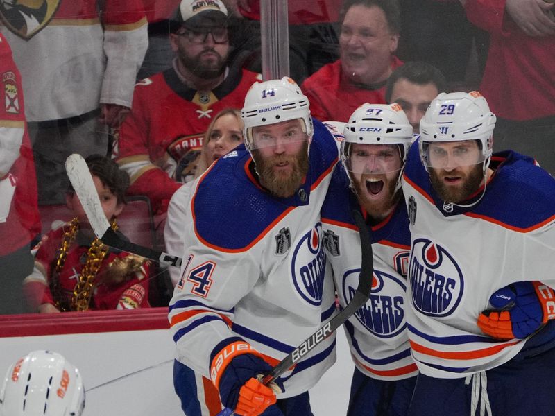 Jun 18, 2024; Sunrise, Florida, USA; Edmonton Oilers forward Connor McDavid (97) celebrates scoring an empty net goal with defenseman Mattias Ekholm (14) and forward Adam Henrique (19) and defenseman Evan Bouchard (2) and forward Zach Hyman (18) during the third period against the Florida Panthers in game five of the 2024 Stanley Cup Final at Amerant Bank Arena. Mandatory Credit: Jim Rassol-USA TODAY Sports