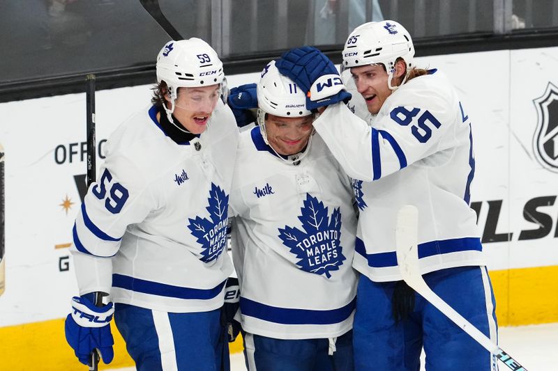 Feb 22, 2024; Las Vegas, Nevada, USA; Toronto Maple Leafs center Max Domi (11) celebrates with left wing Tyler Bertuzzi (59) and defenseman William Lagesson (85) after scoring a goal against the Vegas Golden Knights during the first period at T-Mobile Arena. Mandatory Credit: Stephen R. Sylvanie-USA TODAY Sports