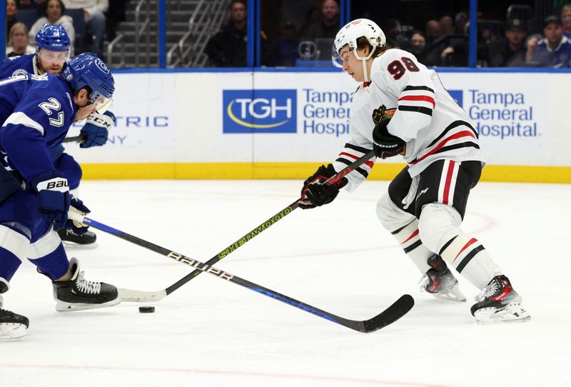 Jan 28, 2025; Tampa, Florida, USA; Chicago Blackhawks center Connor Bedard (98) skates with the puck as Tampa Bay Lightning defenseman Ryan McDonagh (27) defends  during the second period at Amalie Arena. Mandatory Credit: Kim Klement Neitzel-Imagn Images