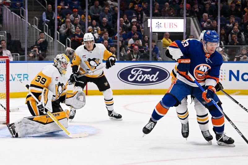 Apr 17, 2024; Elmont, New York, USA;  New York Islanders center Casey Cizikas (53) deflects the puck in front of Pittsburgh Penguins goaltender Alex Nedeljkovic (39) during the second period at UBS Arena. Mandatory Credit: Dennis Schneidler-USA TODAY Sports