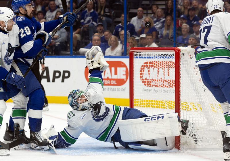 Oct 15, 2024; Tampa, Florida, USA; Vancouver Canucks goaltender Arturs Silovs (31) makes a save against the Tampa Bay Lightning during the first period at Amalie Arena. Mandatory Credit: Kim Klement Neitzel-Imagn Images