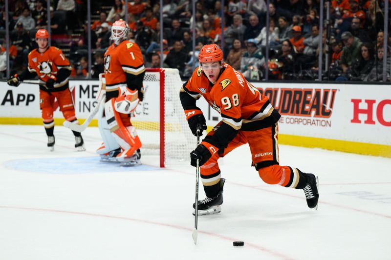 Oct 16, 2025; Anaheim, California, USA; Anaheim Ducks defenseman Pavel Mintyukov (98) controls the puck during the first period against the Carolina Hurricanes at Honda Center. Mandatory Credit: William Liang-Imagn Images