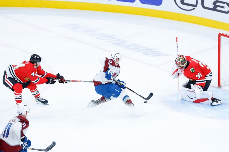 Nov 23, 2025; Chicago, Illinois, USA; Chicago Blackhawks defenseman Wyatt Kaiser (44) defends against Colorado Avalanche center Ross Colton (20) during the third period at United Center. Mandatory Credit: Kamil Krzaczynski-Imagn Images