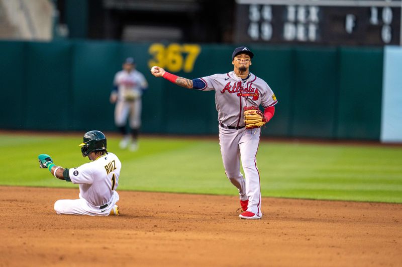 May 30, 2023; Oakland, California, USA;  Atlanta Braves shortstop Orlando Arcia (11) completes the double play as Oakland Athletics center fielder Esteury Ruiz (1) slides into second base during the fifth inning at Oakland-Alameda County Coliseum. Mandatory Credit: Neville E. Guard-USA TODAY Sports