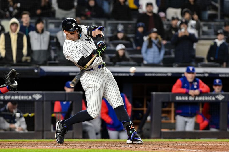 May 21, 2025; Bronx, New York, USA; New York Yankees outfielder Aaron Judge (99) hits a RBI single against the Texas Rangers during the eighth inning at Yankee Stadium. Mandatory Credit: John Jones-Imagn Images