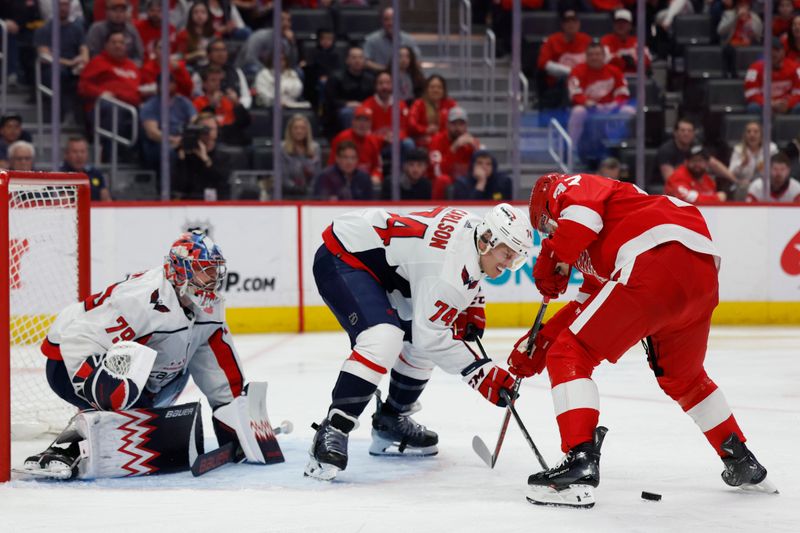 Apr 9, 2024; Detroit, Michigan, USA;  Detroit Red Wings left wing J.T. Compher (37) and Washington Capitals defenseman John Carlson (74) battle for the puck in the second period in front of goaltender Charlie Lindgren (79) at Little Caesars Arena. Mandatory Credit: Rick Osentoski-USA TODAY Sports