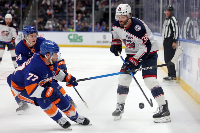 Mar 22, 2026; Elmont, New York, USA; Columbus Blue Jackets center Boone Jenner (38) plays the puck against New York Islanders defenseman Tony DeAngelo (77) and center Calum Ritchie (64) during the third period at UBS Arena. Mandatory Credit: Brad Penner-Imagn Images Mar 22, 2026; Elmont, New York, USA; Columbus Blue Jackets center Boone Jenner (38) plays the puck against New York Islanders defenseman Tony DeAngelo (77) and center Calum Ritchie (64) during the third period at UBS Arena. Mandatory Credit: Brad Penner-Imagn Images