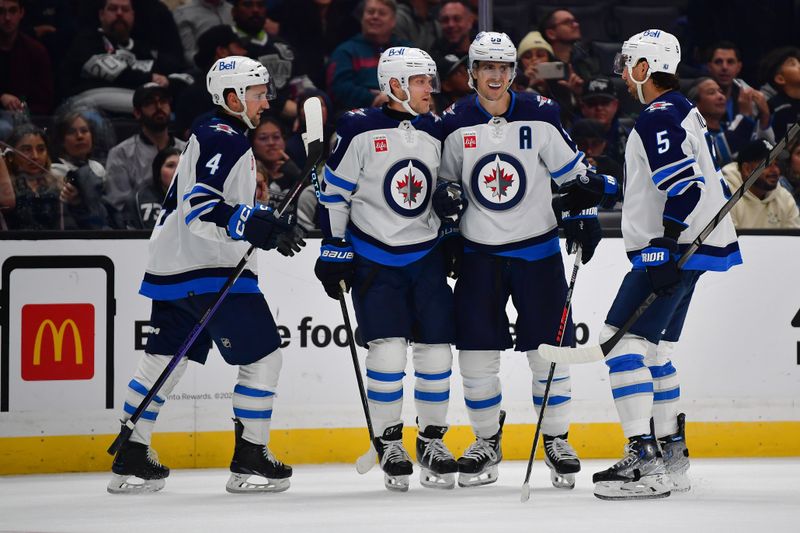 Dec 13, 2023; Los Angeles, California, USA; Winnipeg Jets center Mark Scheifele (55) celebrates his empty net goal scored against the Los Angeles Kings with defenseman Neal Pionk (4) left wing Nikolaj Ehlers (27) and defenseman Brenden Dillon (5) during the third period at Crypto.com Arena. Mandatory Credit: Gary A. Vasquez-USA TODAY Sports