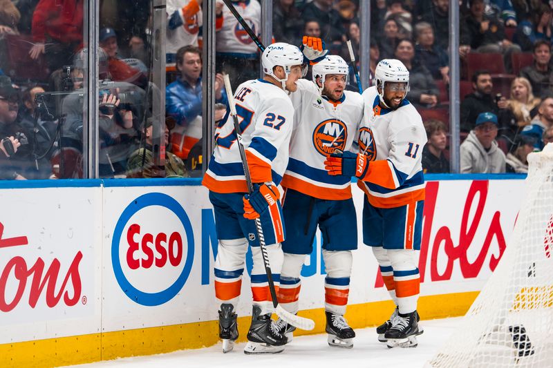 Jan 19, 2026; Vancouver, British Columbia, CAN; New York Islanders defenseman Tony DeAngelo (77) celebrates with forwards Anthony Duclair (11) and Anders Lee (27) after scoring a goal against the Vancouver Canucks in the third period at Rogers Arena. Mandatory Credit: Bob Frid-Imagn Images