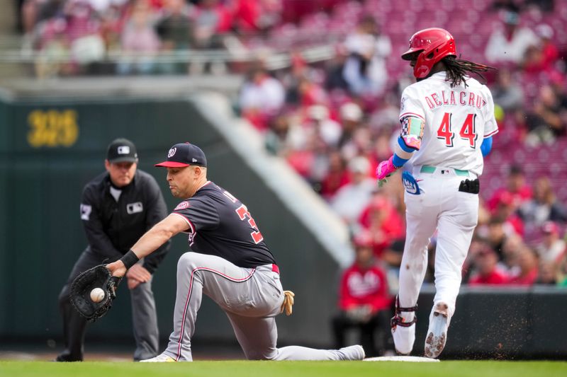 May 4, 2025; Cincinnati, Ohio, USA;  Washington Nationals first baseman Nathaniel Lowe (33) fields the ball as Cincinnati Reds shortstop Elly De La Cruz (44) reaches safely at first base in the first inning inning at Great American Ball Park. Mandatory Credit: Aaron Doster-Imagn Images