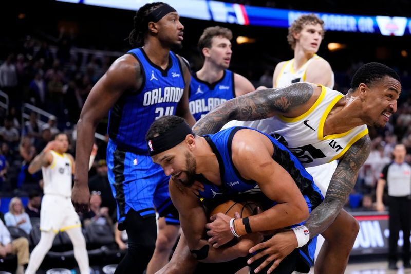 ORLANDO, FLORIDA - FEBRUARY 29: Jalen Suggs #4 of the Orlando Magic and John Collins #20 of the Utah Jazz compete for a loose ball during the fourth quarter at Kia Center on February 29, 2024 in Orlando, Florida. NOTE TO USER: User expressly acknowledges and agrees that, by downloading and or using this photograph, user is consenting to the terms and conditions of the Getty Images License Agreement. (Photo by Rich Storry/Getty Images)