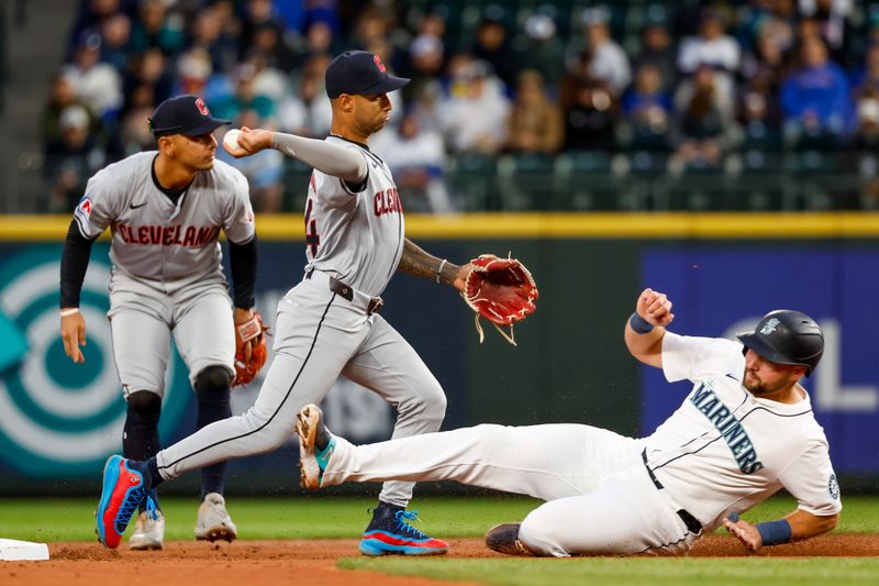 Apr 2, 2024; Seattle, Washington, USA; Cleveland Guardians shortstop Brayan Rocchio (4) turns a double play against Seattle Mariners catcher Cal Raleigh (29) during the second inning at T-Mobile Park. Mandatory Credit: Joe Nicholson-USA TODAY Sports