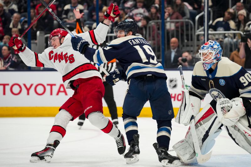 Nov 23, 2024; Columbus, Ohio, USA;  Columbus Blue Jackets center Adam Fantilli (19) clears Carolina Hurricanes right wing Andrei Svechnikov (37) from the goal crease in the first period at Nationwide Arena. Mandatory Credit: Aaron Doster-Imagn Images