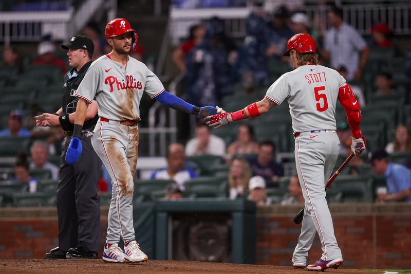 Jun 27, 2025; Atlanta, Georgia, USA; Philadelphia Phillies shortstop Trea Turner (7) celebrates with second baseman Bryson Stott (5) after scoring a run against the Atlanta Braves in the first inning at Truist Park. Mandatory Credit: Brett Davis-Imagn Images
